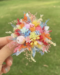 Colorful preserved flower ring held outdoors with green garden background — Eco Perennial