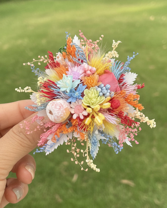 Colorful preserved flower ring held outdoors with green garden background — Eco Perennial