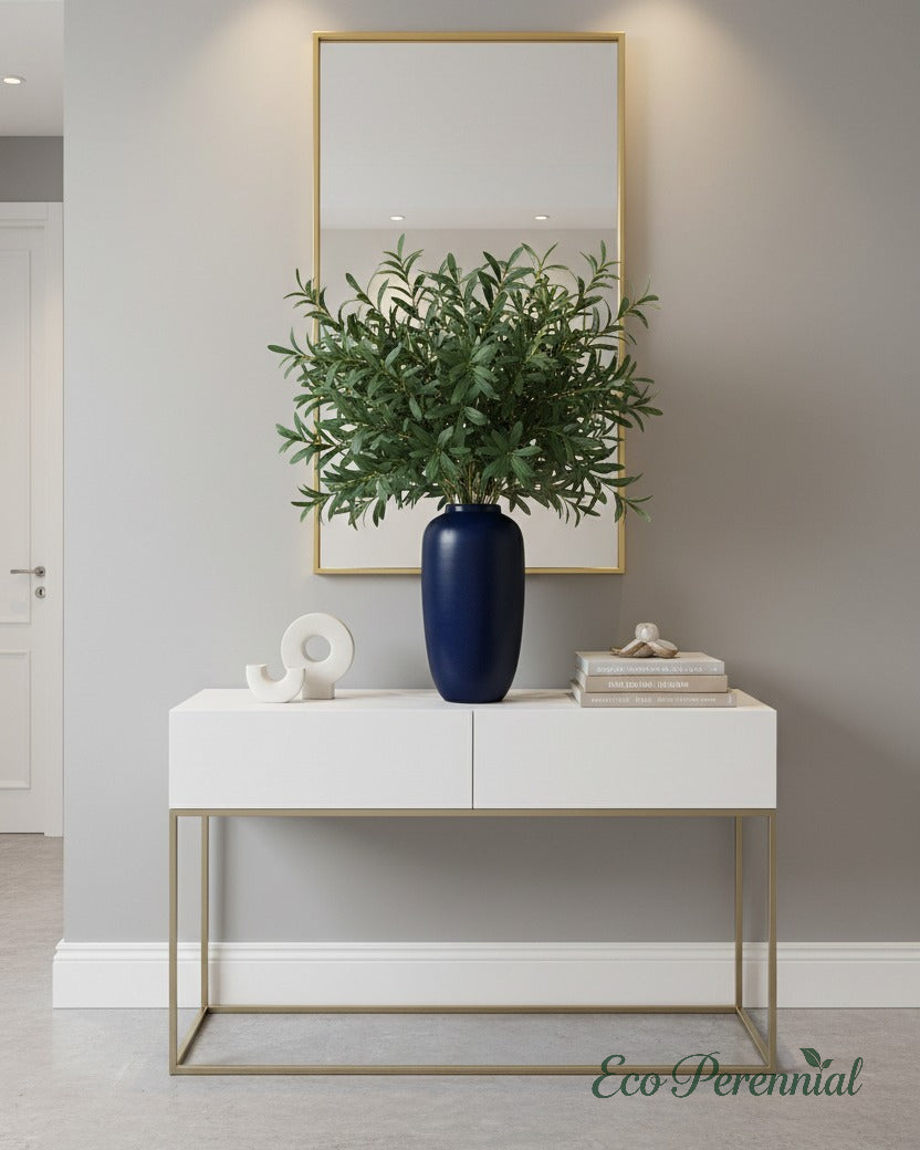 Eco Perennial dense artificial olive branch arrangement displayed in a tall glass cylinder vase on a modern dining sideboard